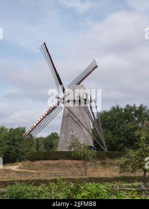 Paesaggio foto di un vecchio mulino a vento a Bokrijk, Belgio con un cielo leggermente nuvoloso Foto Stock