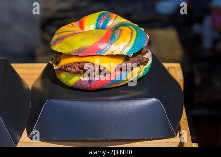 Unicorn Burger Hampshire bistecca sminuzzata rainbow bagel glitterato per la vendita di cibo stalla all'evento a Poole, Dorset Regno Unito nel mese di luglio Foto Stock