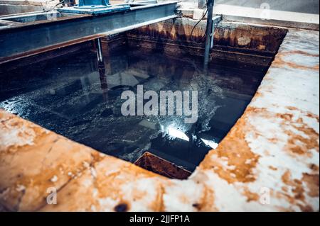 Rifiuti liquidi. Acqua inquinata dopo essere stata utilizzata in acciaieria. Concetto di inquinamento o contaminazione Foto Stock