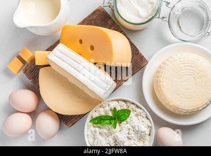 Un assortimento di latticini e uova di pollo in primo piano su sfondo grigio. Foto Stock