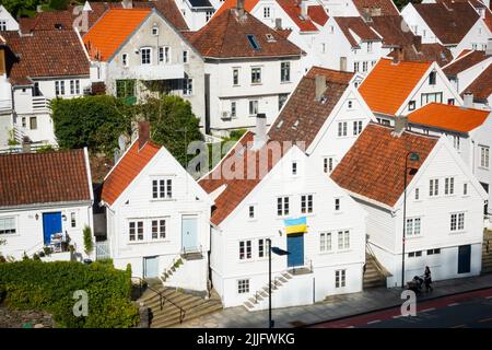 Case in legno tradizionali norvegesi dipinte di bianco a Stavanger, Norvegia. Una bandiera ucraina è volata a sostegno dell'Ucraina Foto Stock