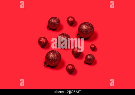 Palline rosse di Natale disposte a forma di cerchio su sfondo luminoso. Foto Stock