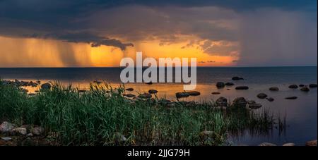 Bella spiaggia massi in un mare calmo Baltico durante un tramonto giallo colorato vicino a Tallinn City. Foto Stock