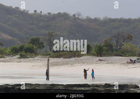 I turisti prendono selfie alla spiaggia pulita di Tanjung Aan a Lombok, Indonesia Foto Stock