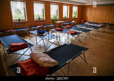 Falkenberg, Germania. 26th luglio 2022. I letti del campo sono pronti in un rifugio di emergenza nella 'Haus des Gastes' per i residenti colpiti dal fuoco della foresta. I vigili del fuoco di Brandeburgo continuano a combattere un grande incendio boschivo nel distretto di Elbe-Elster. Da lunedì (25,07) brucia su una superficie di circa 800 ettari. I primi residenti hanno dovuto lasciare le loro case. (Vista aerea con drone) Credit: Jan Woitas/dpa/Alamy Live News Foto Stock