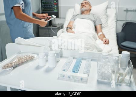 Focalizzazione selettiva sullo shot in primo piano di vari farmaci e strumenti preparati per i pazienti in pronto soccorso Foto Stock