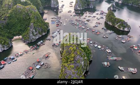 Villaggio galleggiante di pescatori e isola rocciosa nella baia di ' LAN ha ', Vietnam, Asia sud-orientale. Sito patrimonio dell'umanità dell'UNESCO. Orizzontale. Punto di riferimento popolare, famoso d Foto Stock