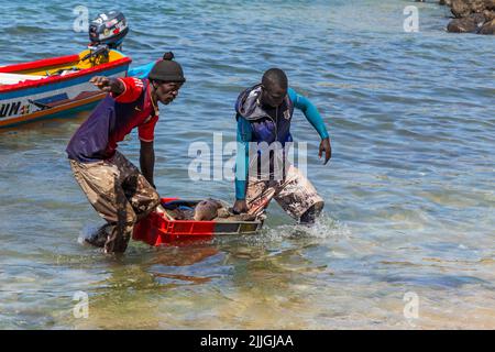 Dakar, Senegal. 18 agosto 2019: Pescatori con una barca da pesca in una spiaggia a Dakar, una delle molte spiagge di pesca di Dakar, Senegal, Africa occidentale Foto Stock