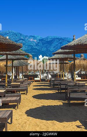 Vista su sdraio e ombrelloni sulla spiaggia sabbiosa di Kemer, Turchia. Foto Stock