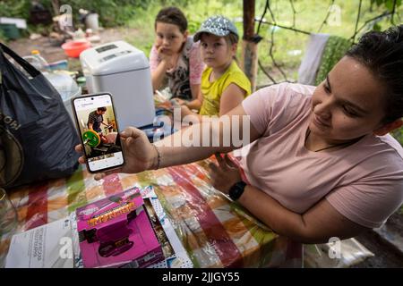 19 luglio 2022, Slovyansk, Ucraina: Zalta mostra la foto della sua pratica di sollevamento pesi prima della guerra, in quanto è la candidata squadra nazionale Ucraina dei Giochi Paralimpici, come ora vive in una casa senza elettricità, acqua e gas con due delle sue sorelle Masha, Sana e genitori, con 5 gatti, 3 cani, anatre e polli in Slovyansk, Donbas. Sebbene l'avanzata russa si stia avvicinando sempre più, alcuni cittadini slovacchi per vari motivi hanno deciso di restare indietro. Slovyansk con una popolazione di 106.972 abitanti (2021 est.), ora si erge come una delle principali città strategiche della Foto Stock