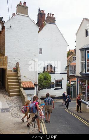 The Laurel inn at Robin Hood's Bay, con persone che camminano fino alla spiaggia Foto Stock