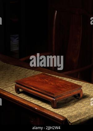 Un antico tavolo cinese di legno Kang sul tavolo contro una sedia di legno Foto Stock