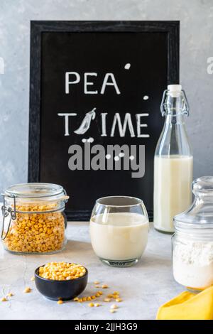 Prodotti sani di piselli - latte di piselli vegani a base vegetale, farina e semi. Sfondo concreto, Mockup per il testo Foto Stock