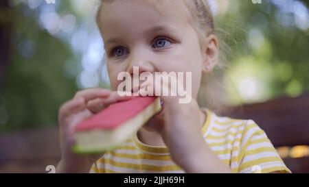 Odessa, Ucraina, Europa dell'Est. 26th luglio 2022. Primo piano di ragazza carina mangia gelato. Primo piano della bambina seduta sul panca del parco e mangiare il icecream. (Credit Image: © Andrey Nekrasov/ZUMA Press Wire) Foto Stock