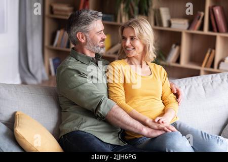 Buon matrimonio. Ritratto di sorridenti sposi di mezza età che abbracciano a casa Foto Stock