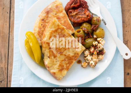 Tortilla di patate con olive, pomodori secchi e insalata di feta Foto Stock