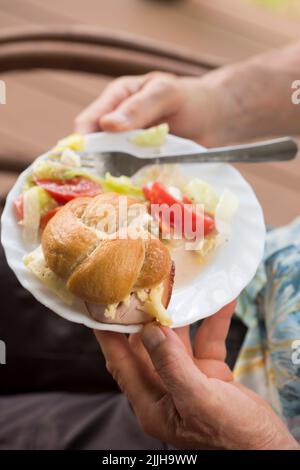 Panino fresco con prosciutto e formaggio e insalata estiva con lattuga, pomodori, formaggio feta Foto Stock