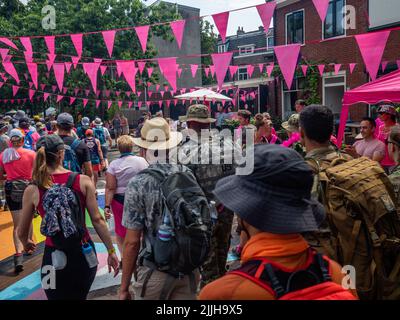 I partecipanti sono visti arrivare in un quartiere decorato con bandiere rosa durante il più grande evento a piedi di più giorni del mondo. La marcia dei quattro giorni (in olandese 'Vierdaagse') è vista come il primo esempio di sportività e di legame internazionale tra militari e civili di molti paesi diversi. Dopo due anni di cancellazioni, si è tenuto di nuovo, ma il primo giorno è stato annullato a causa delle temperature calde, trasformando le quattro marce in tre giorni marce. Questa è l'edizione del 104 e il totale ufficiale degli escursionisti registrati è stato di 38.455 provenienti da 69 paesi. Possono scegliere di camminare 3 Foto Stock