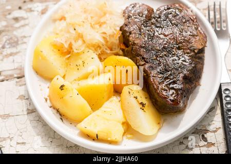 Bistecca di manzo con patate fritte e cavolo e carota slaw Foto Stock