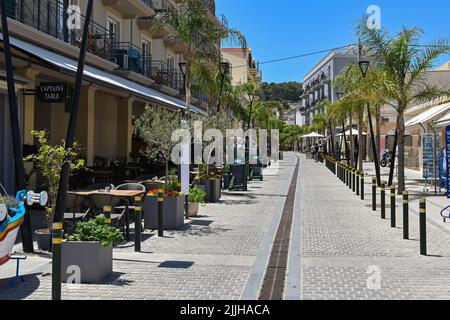 Argostili, Cefalonia, Grecia - Giugno 2022: Strada nel centro della città fiancheggiata da ristoranti e bar Foto Stock