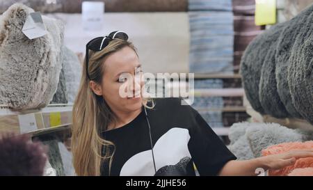 La ragazza nel deposito sta scegliendo i cuscini per la casa. Foto Stock