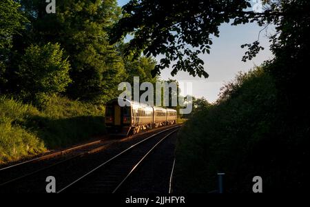 Treno sprinter di classe 158 della Northern Rail che si dirige verso il tramonto sulla piccola linea ferroviaria nord-occidentale nel North Yorkshire, Regno Unito Foto Stock