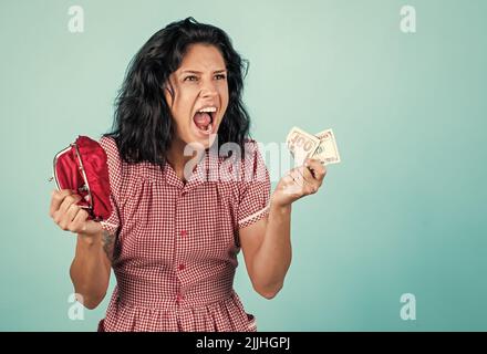 Economia shopaholic. E concetto di crisi. Donna casalinga ha un problema finanziario. Ragazza bisogno di prestito o di credito. Pianificazione del reddito. Donna arrabbiata tenere portafoglio Foto Stock