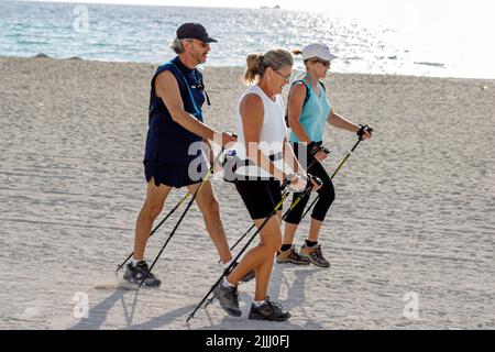 Miami Beach Florida,Atlantic Ocean Shore costa costa costa costa costa costa mare, nordic walking bastoncini sci pubblico, sabbia, allenamento Foto Stock