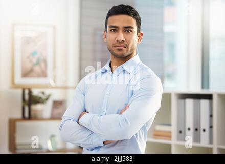 Feroce di fronte alle avversità professionali, un bel giovane uomo d'affari nel suo ufficio. Foto Stock