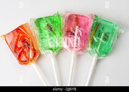 Lollipop rosa, verde e arancione con piccoli animali all'interno Foto Stock