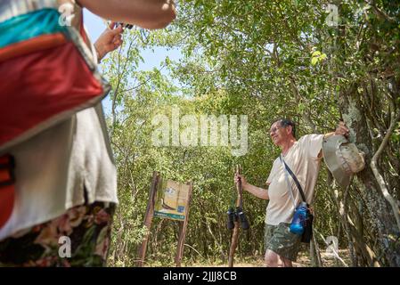 Dicembre 31, 2021, El Palmar National Park, Entre Rios, Argentina: Coppia turistica ispanica matura, lei scatta foto di lui come si riposano mentre trekking uno di Foto Stock