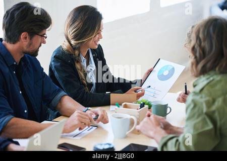 Giovane donna in possesso di un documento che presenta i dati finanziari ai colleghi per incontrare idee di brainstorming utilizzando la ricerca di mercato Foto Stock