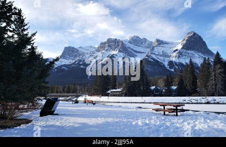 montagna innevata vicino al fiume Foto Stock