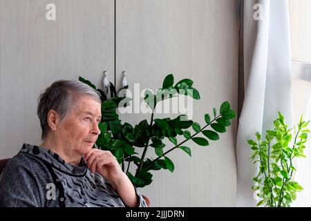 Donna anziana in pensione seduta in veranda in depressione, solitudine. Donna anziana in attesa, con spazio copia, fuoco selettivo.Global giorno dei genitori Foto Stock