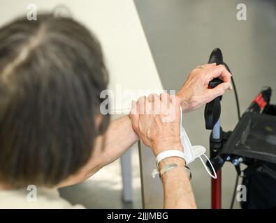 Potsdam, Germania. 26th luglio 2022. Una donna ha messo le mani sulle maniglie di un camminatore durante una visita di Red Nose Clowns a Klinikum Ernst von Bergmann. Le visite clown sono state sviluppate appositamente per i pazienti con compromissione fisica o mentale e aiutano a migliorare la loro qualità di vita. Credit: Jens Kalaene/dpa/Alamy Live News Foto Stock