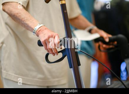 Potsdam, Germania. 26th luglio 2022. Una donna spinge un escursionista durante una visita di Red Nose Clowns al Klinikum Ernst von Bergmann. Le visite clown sono state sviluppate appositamente per i pazienti con compromissione fisica o mentale e aiutano a migliorare la loro qualità di vita. Credit: Jens Kalaene/dpa/Alamy Live News Foto Stock