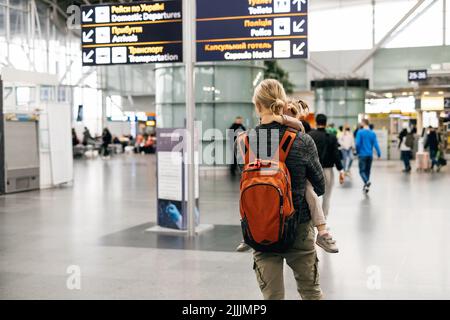 Famiglia in attesa vicino aeroporto cartello, arrivo e partenza zona. Uomo e ragazza felice pronta ad andare in aereo, padre va in vacanza con la figlia. Foto Stock