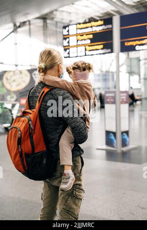 Famiglia in attesa vicino aeroporto cartello, arrivo e partenza zona. Uomo e ragazza felice pronta ad andare in aereo, padre va in vacanza con la figlia. Foto Stock