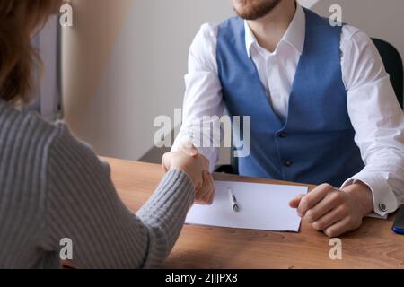 Primo piano uomini d'affari si salutano a vicenda avviando negoziati, handshake HR handshake con candidatura vacante, concetto di risorse umane. Conclusione di una trattativa e firma dei documenti Foto Stock