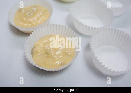 Versare l'impasto del muffin negli stampi Foto Stock