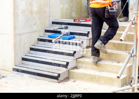 Passi concreti in costruzione come un team di costruttori installare blocchi di cemento pesanti Foto Stock