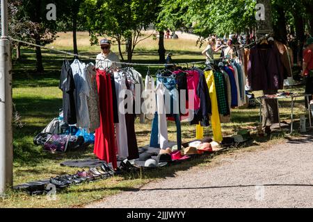 Vestiti appesi sulla corda a Lapinlahden puistokirppis o Lapinlahti pop-up Jumble sale a Helsinki, Finlandia Foto Stock