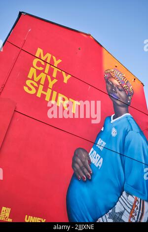 Un enorme murale dipinto su un edificio, caratterizzato da una donna incinta, con orgoglio dicendo Cardiff è la sua città. A Cardiff, Galles, Regno Unito. Foto Stock