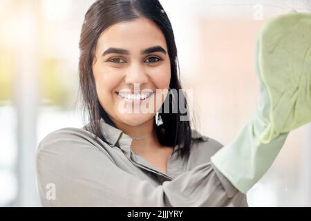 Più splinda che mai, una giovane donna che lavava le finestre a casa. Foto Stock