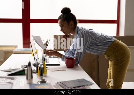 Immagine di un'artista biraciale femminile che fa la documentazione in studio Foto Stock