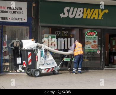 Una pulitrice elettrica per rifiuti urbani Glutton H2O con operatore di pulizia rifiuti nel centro di Sunderland, Inghilterra, Regno Unito Foto Stock