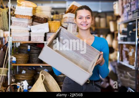 Consumatore giovane donna positivo che tiene la scatola di legno Foto Stock