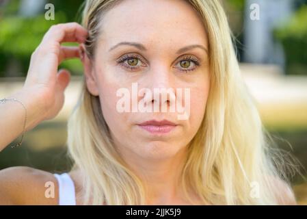Donna pensiva di mezza età che guarda a lato con un'espressione premurosa in un primo piano Foto Stock