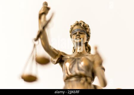 Un fuoco selettivo di una statua d'oro di Themis- la personificazione della giustizia, dell'ordine divino, dell'equità, della legge e dell'abitudine, Scale di giustizia Foto Stock