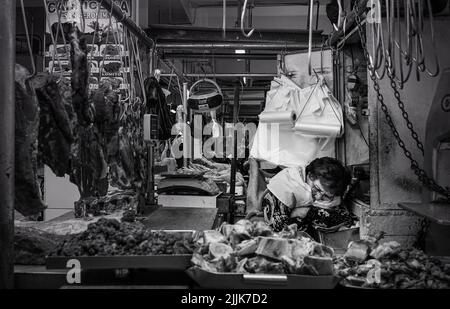 Un primo piano di una donna che snooze alla sua stalla di carne nel Mercado Central, Lima, Perù Foto Stock